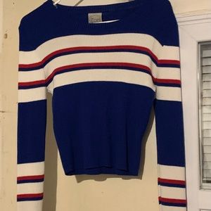 A blue white and red striped sweater .